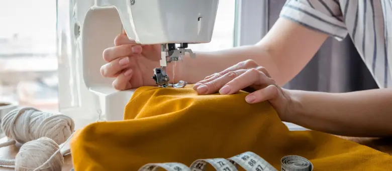 Fashion designer working on a sewing machine.
