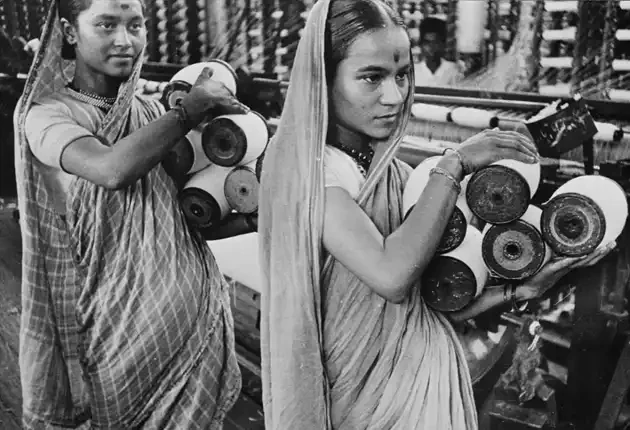 Women workers carrying spindles in factory Women workers carrying spindles in factory